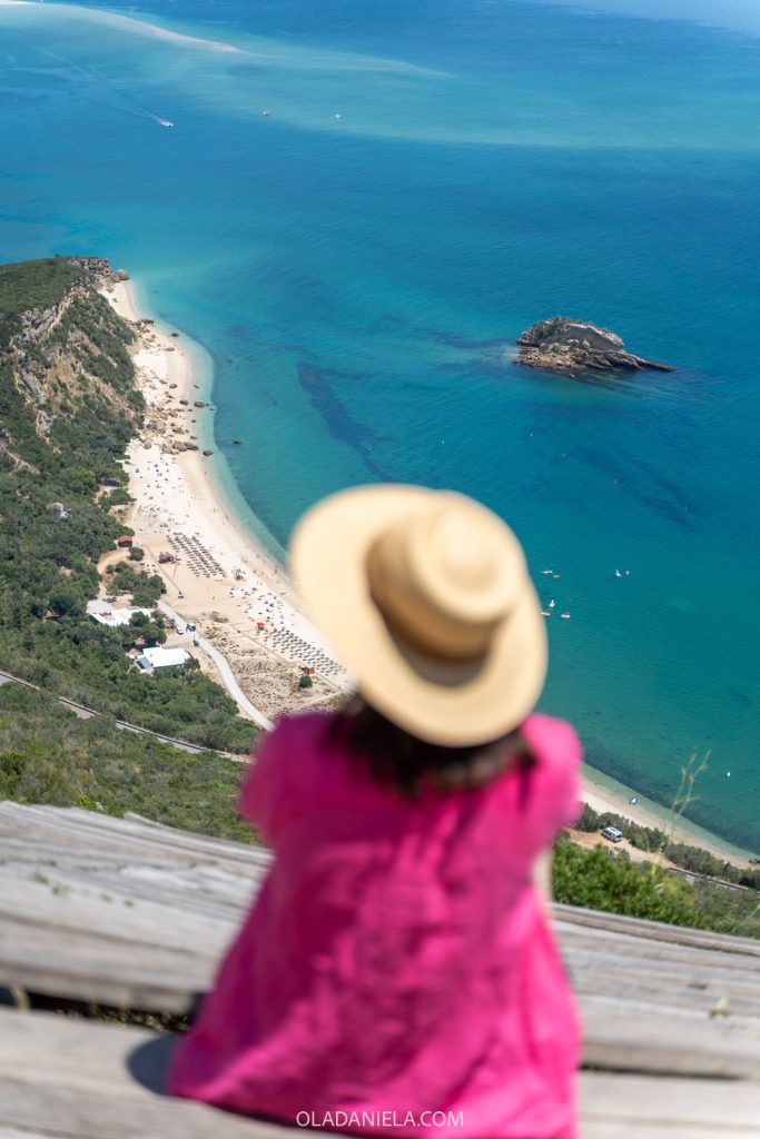 A woman looking down at Praia do Creiro Beach in Arrábida Natural Park